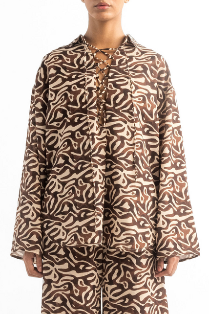 Person wearing a brown and beige patterned outfit on a white background