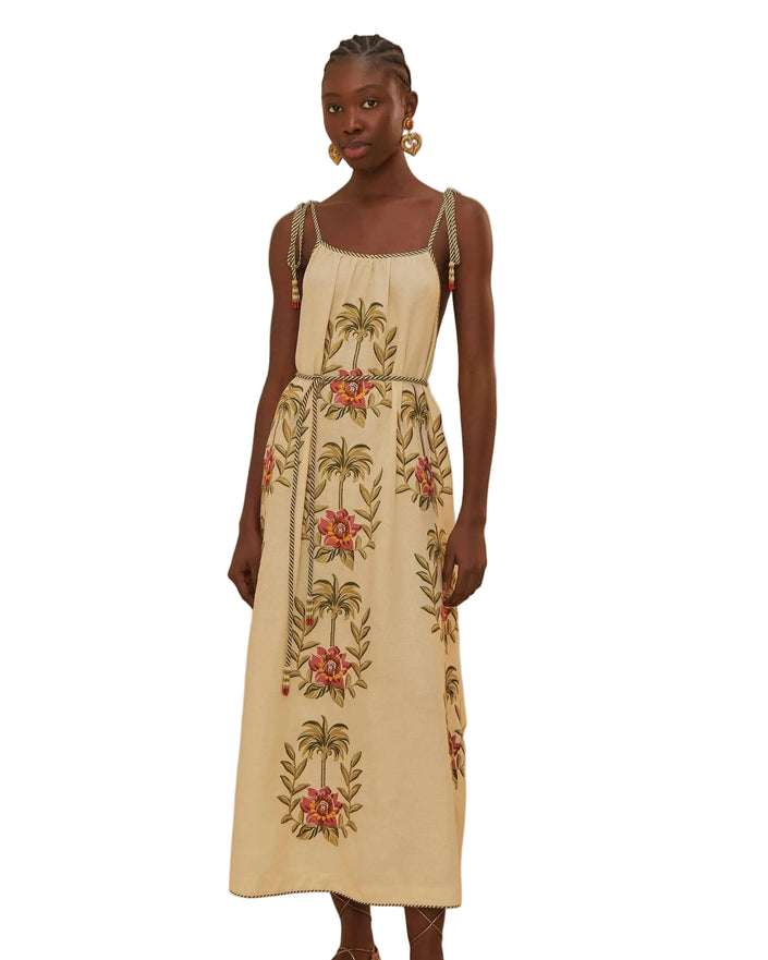 Woman wearing a beige dress with floral embroidery on a beige background