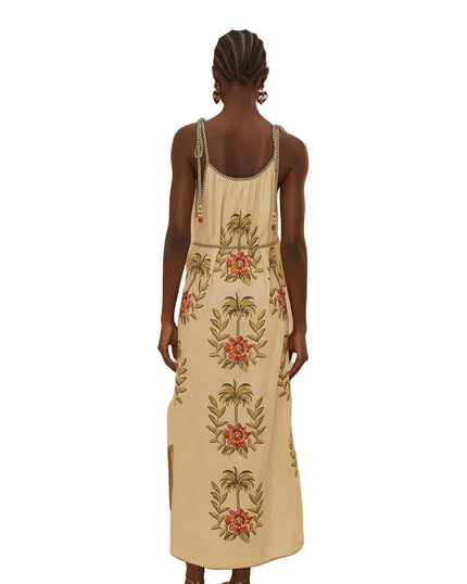 Woman wearing a beige dress with floral embroidery on a beige background