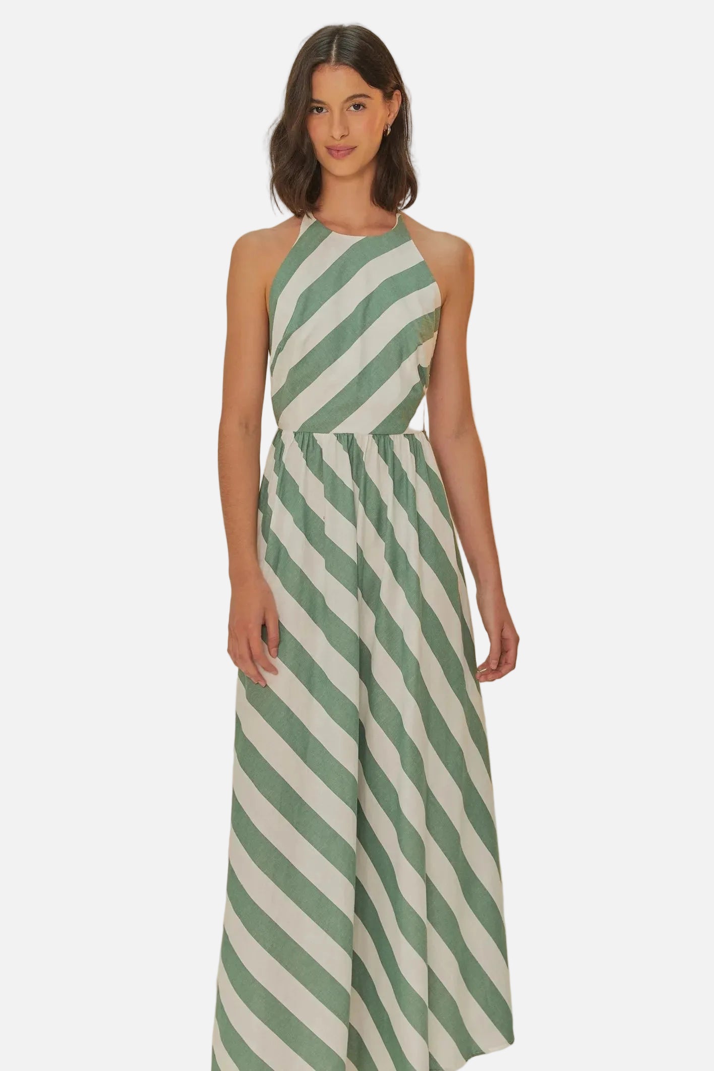 Woman wearing a green and white striped jumpsuit on a beige background