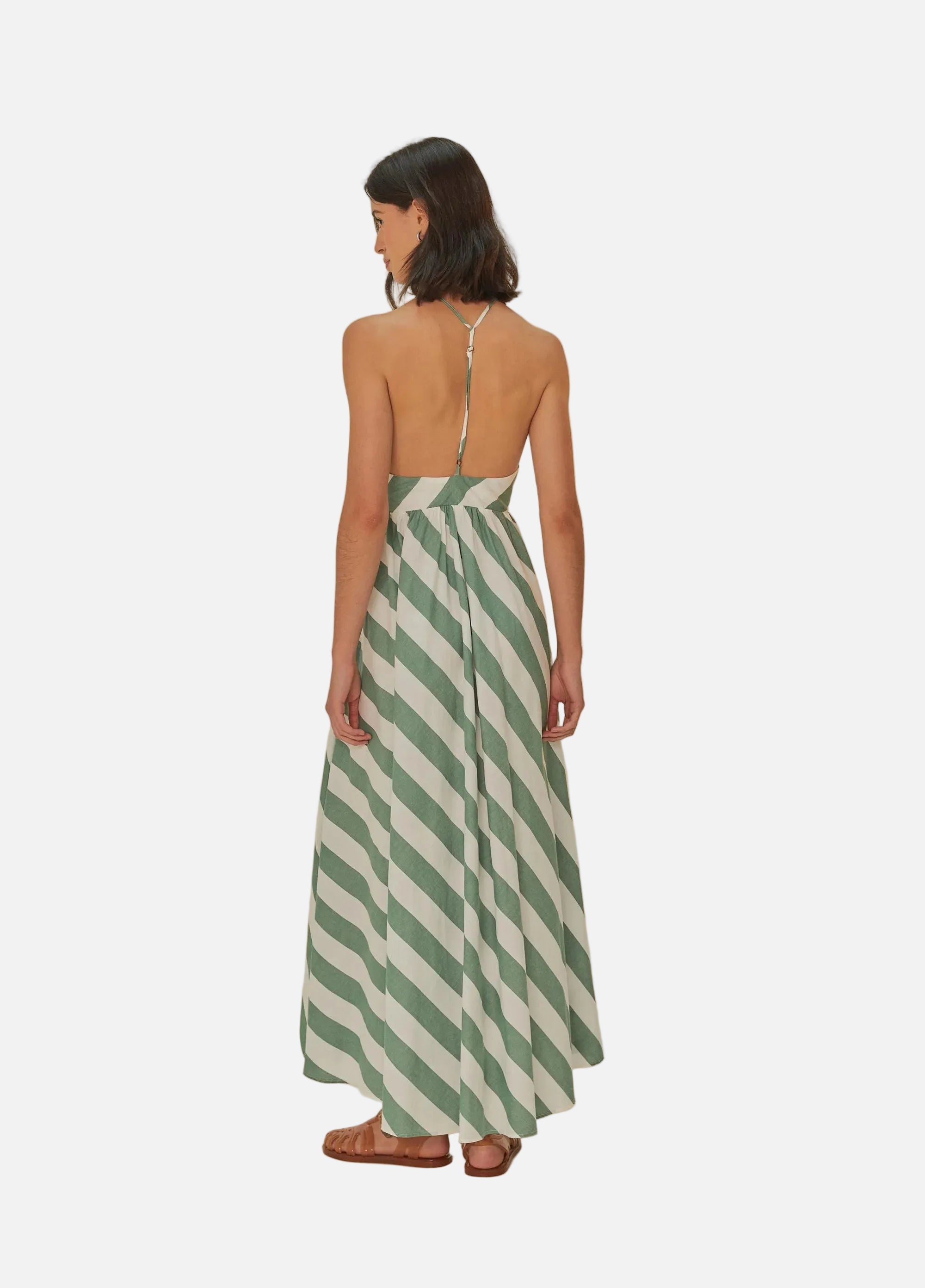 Woman wearing a green and white striped dress on a beige background