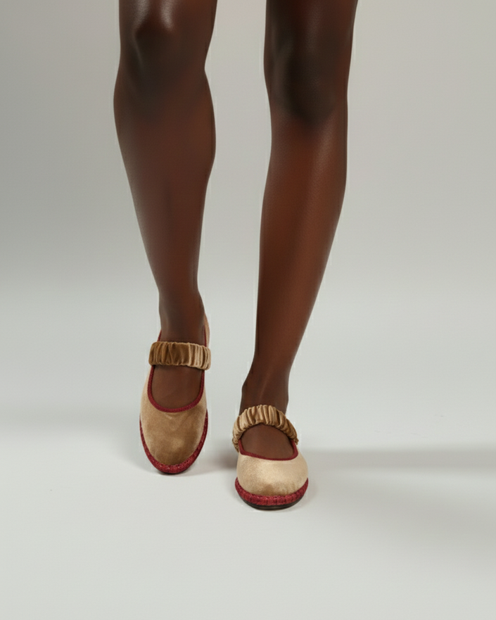 Beige sandals with red soles worn by a person on a white background