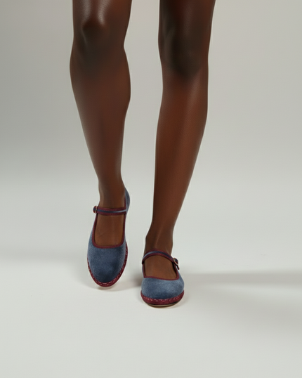 Blue shoes worn with tights on a plain background