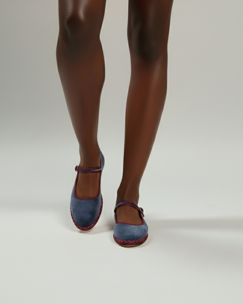 Blue shoes worn with tights on a plain background