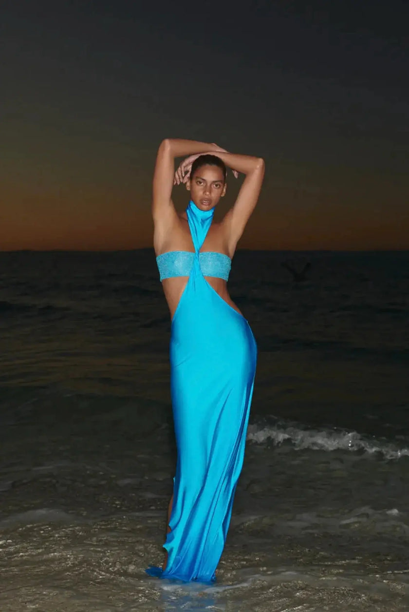Model wearing the sky blue Aluna Dress, showcasing its one-shoulder neckline and side cutout detail.
