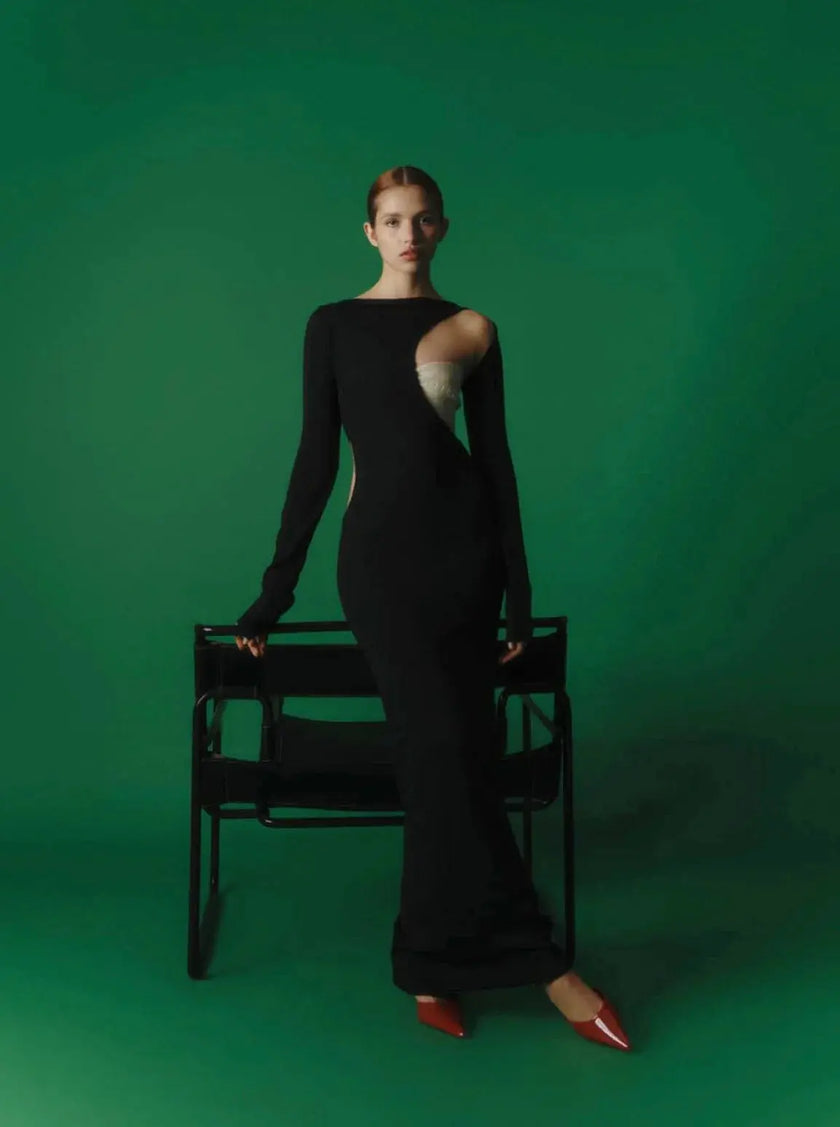 Frontal view of the Baobab Frida Dress with one-shoulder neckline and cutouts, styled with red heels in studio setting.