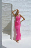 Model wearing the Fucsia-colored Lia Dress, showcasing its one-shoulder design with front cutout and side slit.