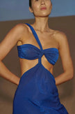 Model wearing the Noche Azul-colored Noah Dress, showcasing its one-shoulder design with asymmetric cutouts and a twisted top detail.