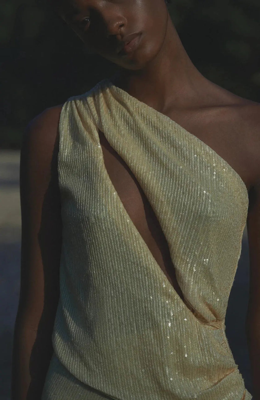 Model wearing the Sunshine-colored Noe Dress, featuring a one-shoulder design with an asymmetric front cutout and ruched detailing.
