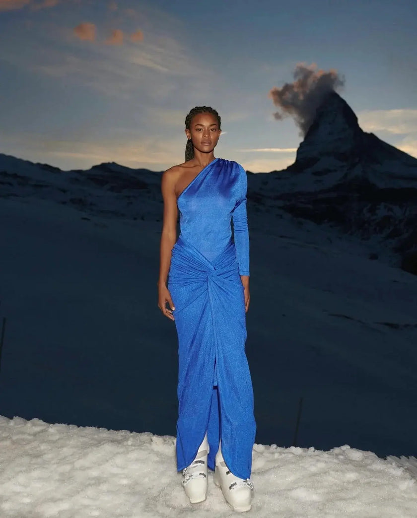 Side view of the Noemi Dress, emphasizing the figure-hugging fit and elegant drape of the maxi-length skirt.