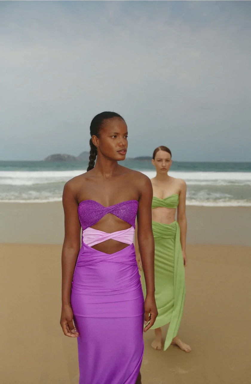 Model at the beach wearing the Efímero-colored Ola Maxi Dress, showcasing its strapless design with a heart-shaped neckline and front cutout details.