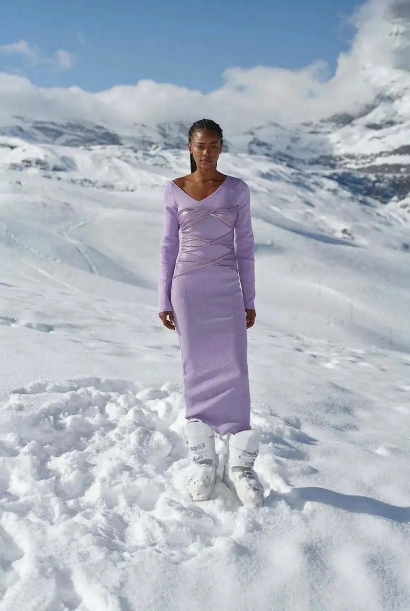 Model wearing the Avril Oleada Dress, showcasing its asymmetrical neckline and glossy mesh overlay on the bodice.