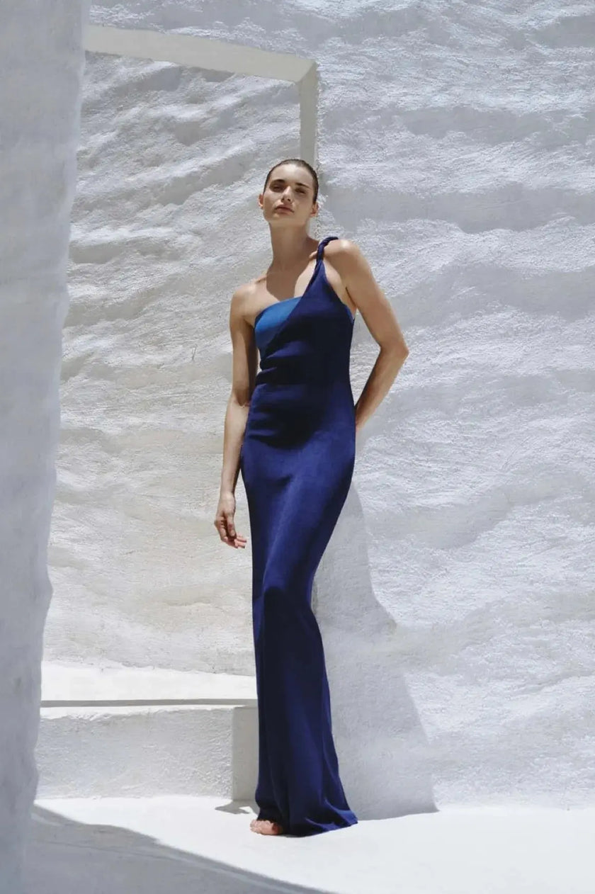 Model wearing the Azure Sombra Dress, showcasing its one-shoulder design and twisted detail at the waist.