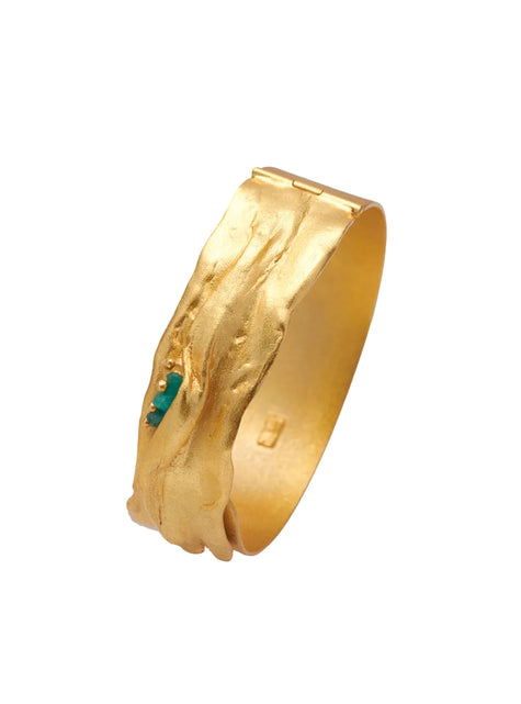 Close-up of the Bimy bracelet, handcrafted in 24k gold-plated bronze with textured surface and embedded Colombian emeralds.