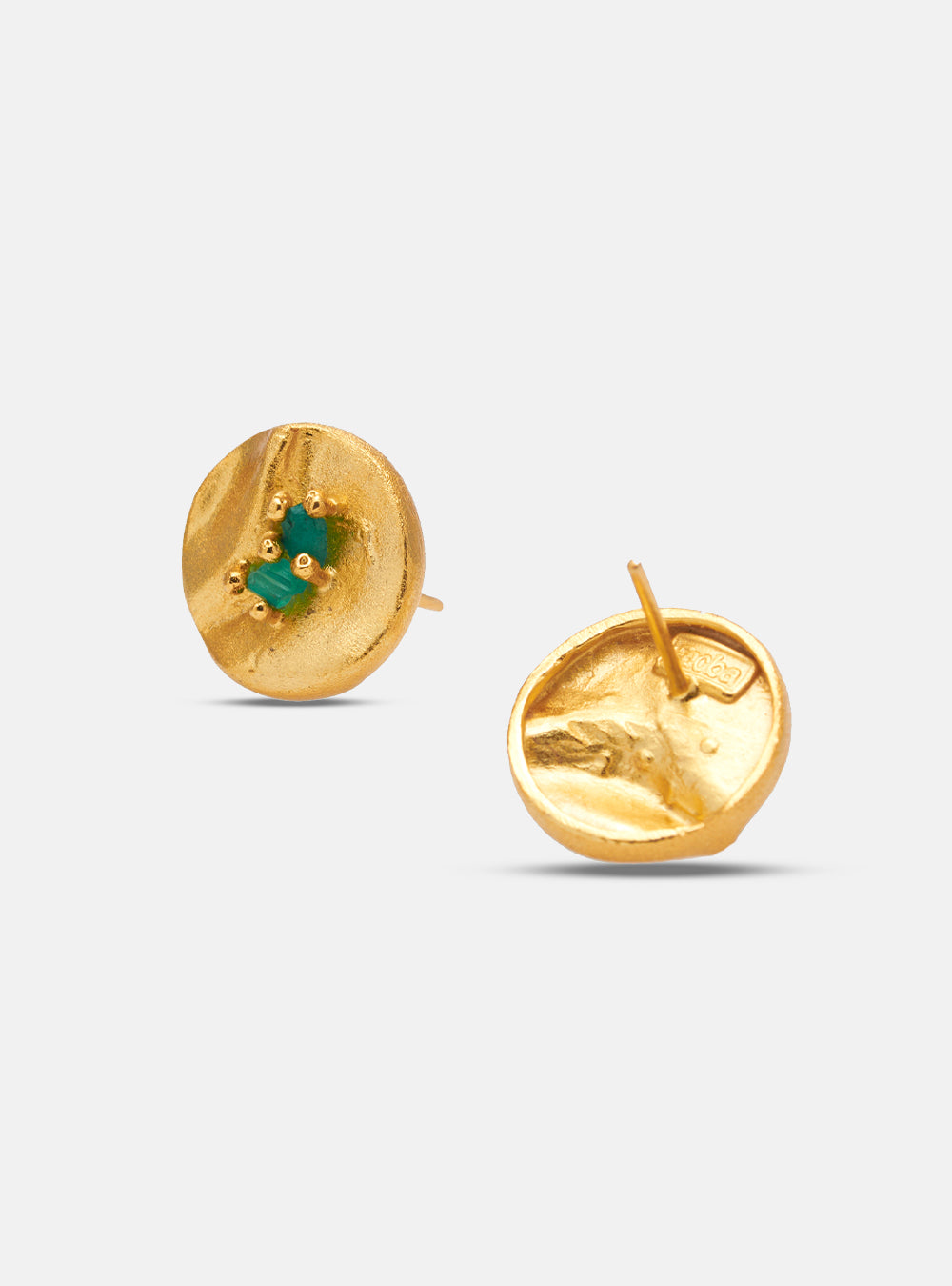 Pair of round, textured gold earrings with green emerald details displayed on a white background.