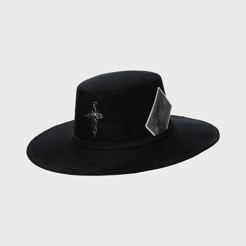 Black felt hat with a silver cross charm and a black card tucked into the band, showcased on a neutral backdrop.