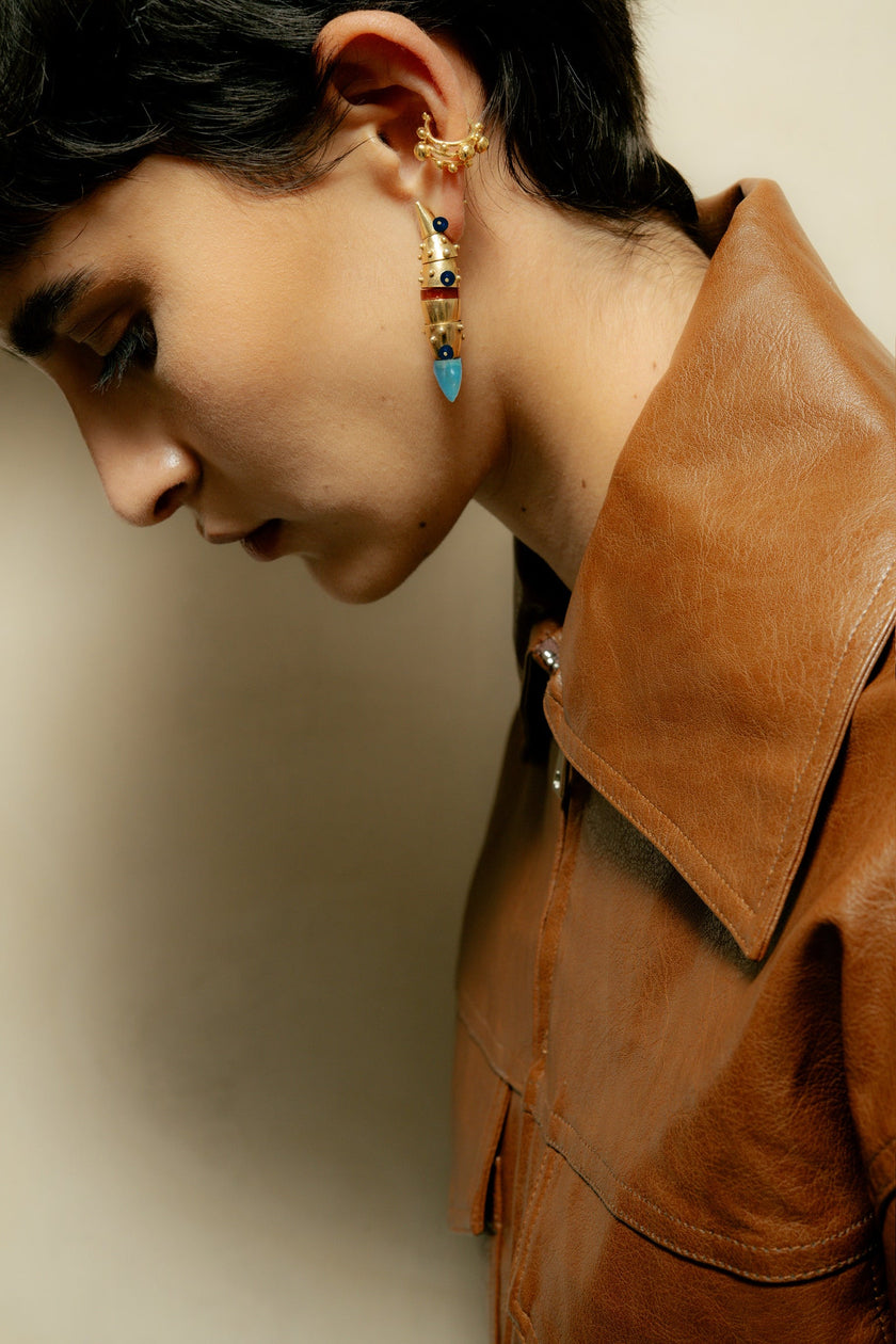 Person wearing a brown leather jacket with a neutral background