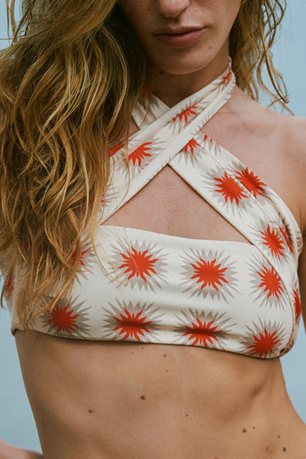 Woman wearing a red and white bikini with a star pattern against a blurred natural background