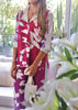 Model standing on a luggage cart in a luxury hotel in Punta Cana, wearing the Francesca Short Set by ANTIBES in vibrant magenta and lilac silk, styled with metallic platform heels for a bold, playful look.