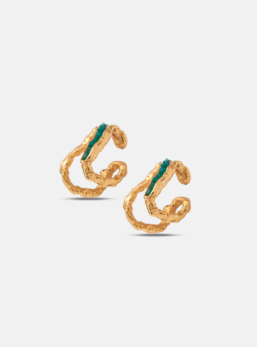 Angled view of gold double hoop earrings with organic texture and embedded emerald stones.