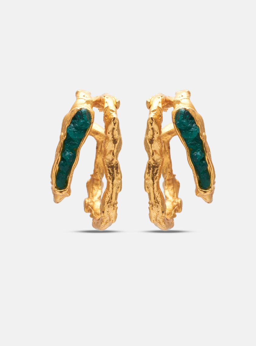Studio shot of handcrafted gold double hoop earrings with rough-cut emerald inlays on a white background.