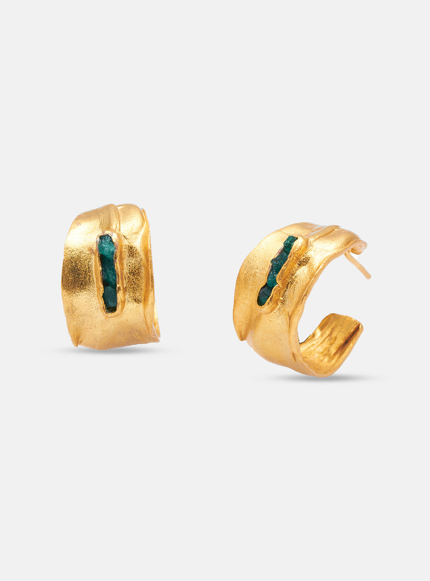 Close-up of Gaxhy earrings highlighting the textured gold surface and vertical emerald detail.