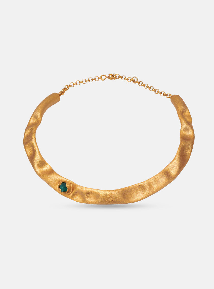 Front view of the Guity Emerald Choker on a white background, featuring a sculpted gold band with a single emerald accent.