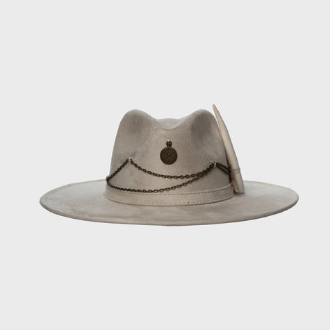 Front-facing view of the Lucky Charm hat in soft taupe suede, featuring antique bronze chains and medallion over a wide structured brim.