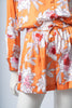 Front view of the orange Lulo set, featuring a V-neckline and relaxed silhouette.