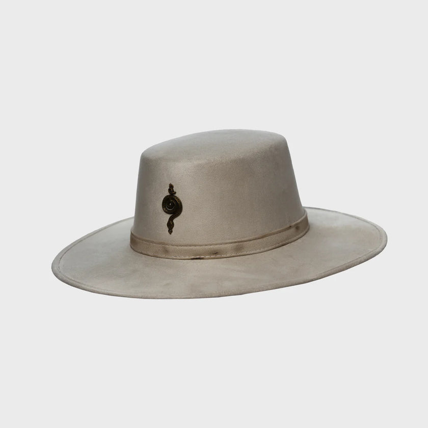 Side profile of the Mamba Charm hat on white background, emphasizing the wide structured brim and the signature antique-gold emblem detail.