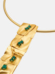 Close-up of the Moky necklace pendant, highlighting its gold texture and vibrant emerald settings.