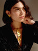 Portrait of a model wearing the Moky necklace and matching earrings, styled with a deep V-neck black dress.