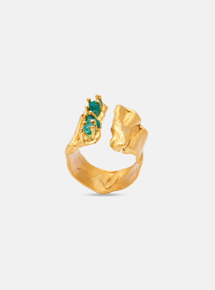 Sculptural gold ring showcasing handcrafted emerald inlays and textured folds.