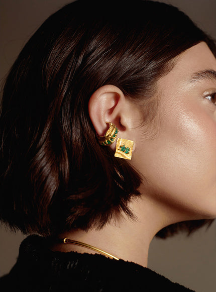 Model wearing the Monky earcuff with matching square gold earring adorned with emerald stones.