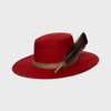Angled side view of deep red suede hat featuring a natural feather accent and textured band, blending elegance and nature.