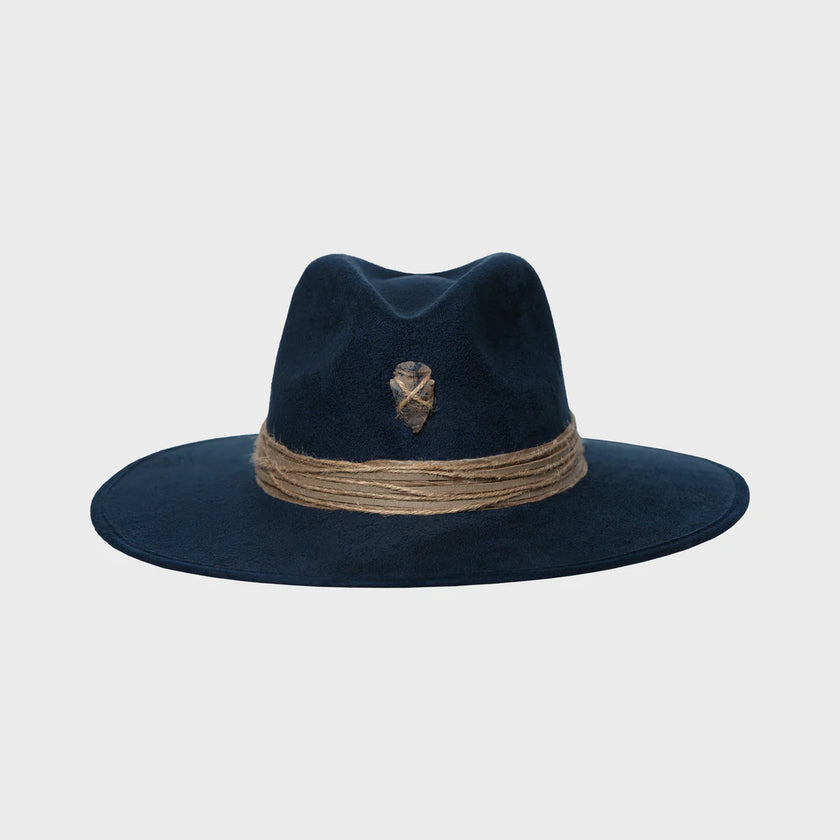 Front-facing image of a navy blue suede hat with natural jute band and an arrowhead emblem stitched at the crown.