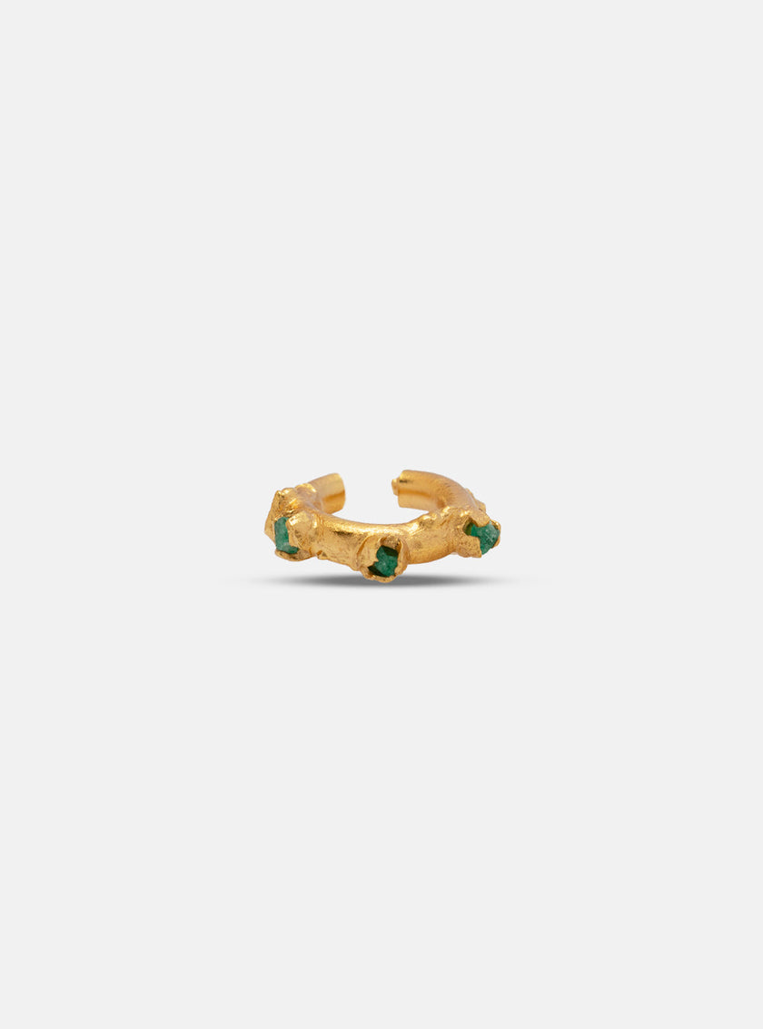 Gold earcuff with organic texture and raw emerald inlays, displayed on a white background.