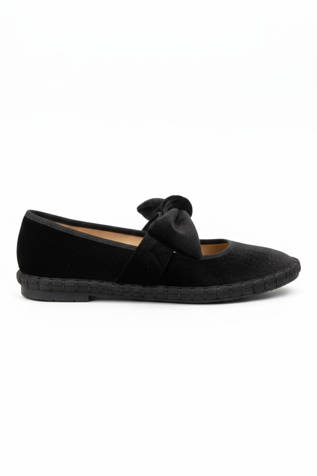 Black flat shoe with a bow on a white background