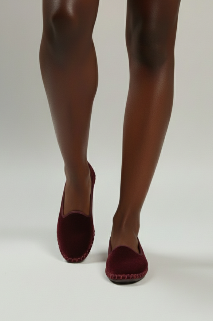 Red high-heeled shoes worn with tights on a white background