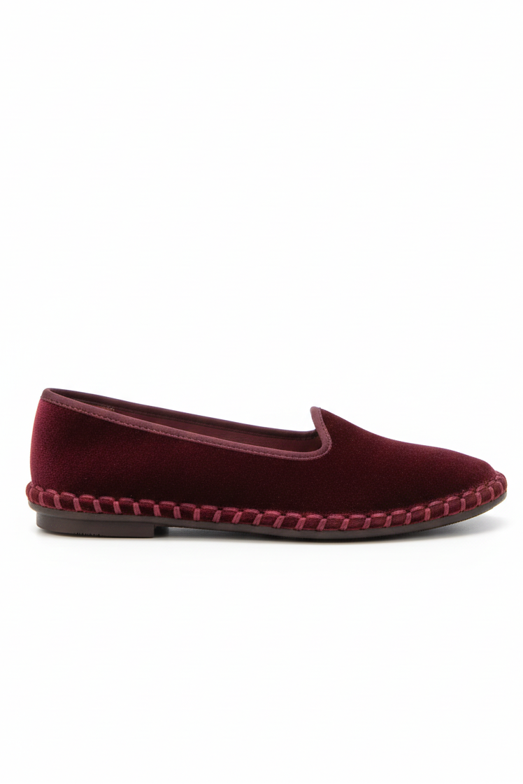 Burgundy slipper with a woven sole on a white background